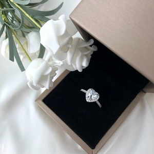 Macro view of a S925 silver ring featuring a pink heart-shaped stone in a brown gift box