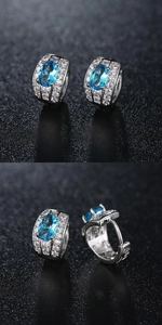 Detailed view of silver hoop earrings with blue oval crystal and pave cubic zirconia