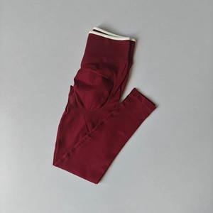 Detail of high waist seamless yoga leggings in wine red with ribbed waistband and contouring seam
