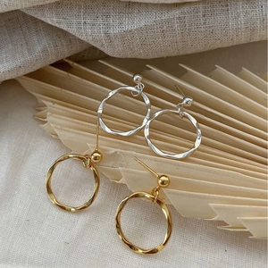 Minimalist irregular hammered round earrings in gold and silver finish on linen