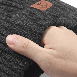 Detail showing the thick dark grey knit texture and faux leather deer logo patch on the hat