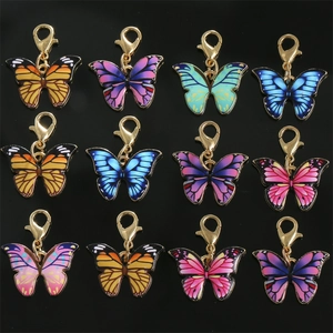 Set of 12 colorful enamel butterfly charms with golden lobster clasps on black background