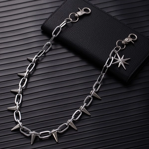 Detail of silver punk pant chain with metal spikes and octagonal star pendant on leather