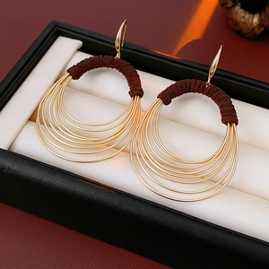 Detail of gold multi-layered hoop earrings with brown thread wrap in a gift box