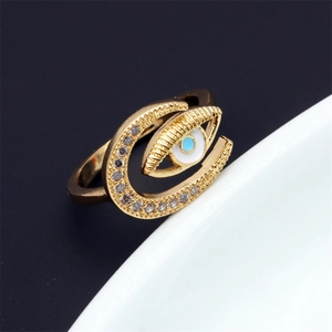 Detail of gold evil eye and crescent moon ring with white cubic zirconia pavé
