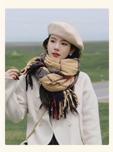 Close-up of soft thick plaid scarf with tassels on female model in outdoor setting