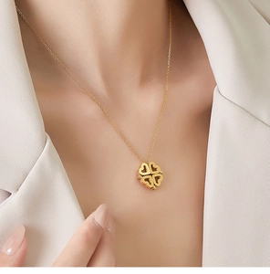 Collier trèfle cœur doré en acier titane plaqué 18K porté sur le cou d'un modèle