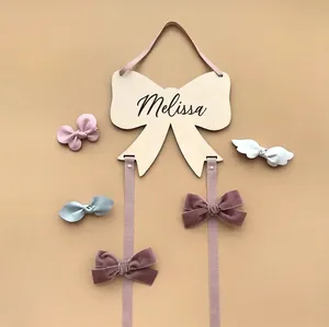 Custom wooden bow hair accessory organizer with personalized name and purple ribbons