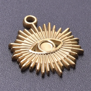 Macro shot of gold stainless steel Evil Eye pendant with sunburst rays and top ring