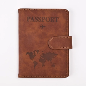 Detail of vintage brown PU leather passport holder with embossed map and flight icons
