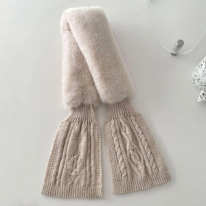 Detail of cream knit scarf featuring plush faux fur and classic cable stitch patterns