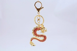 Gros plan d'un porte-clés dragon chinois doré avec strass rouges et détails en perles
