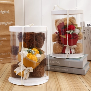 Detail view of plush teddy bear with decorative soap roses in a transparent gift box