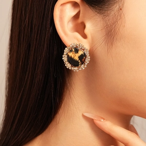 Close-up of vintage leopard print earring with sparkling crystals on female model