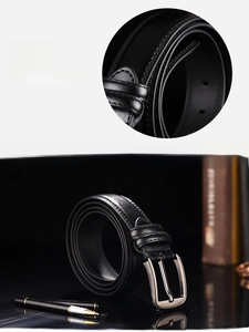 Detail of genuine brown leather belt with silver metal pin buckle and smooth edge oiling