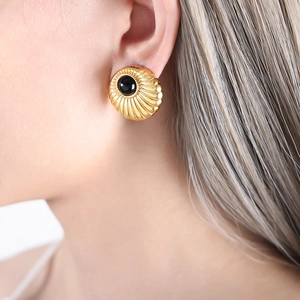 Vintage gold hoop earrings with black onyx center and sunburst texture on model