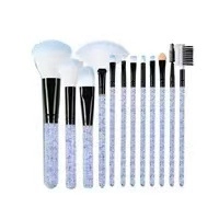 Detail of 12-piece makeup brush set featuring light purple glitter handles and blue bristles