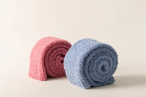 Detail view of soft coral fleece knee-high socks in rolled pink and blue textures