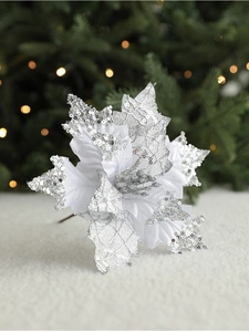 Detailed view of a white Christmas poinsettia with silver sequins on a plush surface