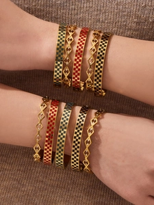 Detail of gold-plated checkered enamel bangles and hollow geometric rhinestone bracelets