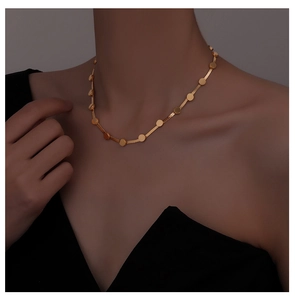 Detail of elegant gold snake chain choker with flat circular metal sequins on model neck