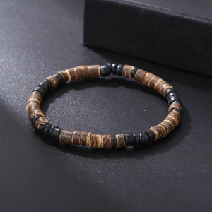 Gedetailleerde weergave van bohemian armband met houten kralen op zwarte getextureerde mat
