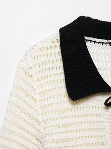 Detailed view of white hollow knit polo shirt showing black collar and woven texture