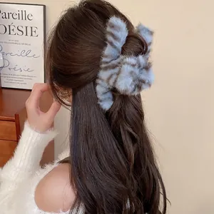 Blue tiger stripe plush hair claw clip for women shown in a soft elegant hairstyle