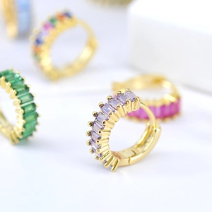 Macro view of gold huggie earrings with baguette-cut lavender zircon gemstones