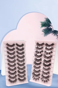 Detailed view of ten pairs of dense, curled false eyelashes in stylish pink packaging