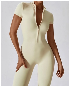 Detail view of the standing collar and front zipper on this beige short sleeve unitard bodysuit