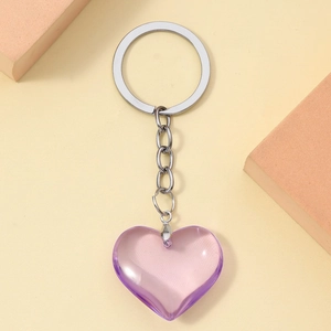 Close-up of a 3D purple resin heart keychain with silver metal ring on a neutral background