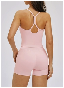 Vue arrière rapprochée d'un ensemble de yoga rose côtelé avec gilet et short ajusté