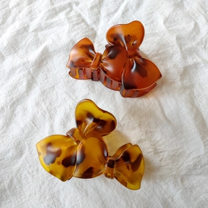 Detail view of bow-shaped tortoiseshell hair claws in amber and leopard patterns
