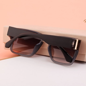 Detail of gradient square lenses and gold metal hinge on black frame sunglasses