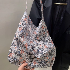 Detailed close-up of floral cotton tote bag texture and reinforced thin shoulder straps