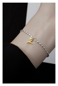 Close-up of S925 silver bracelet featuring a gold letter Y charm and sparkling zircon