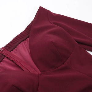 Detailed macro view of the invisible zipper and premium burgundy fabric on long sleeve dress
