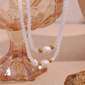 Detail of freshwater pearls and crystal beads draped over vintage amber glassware