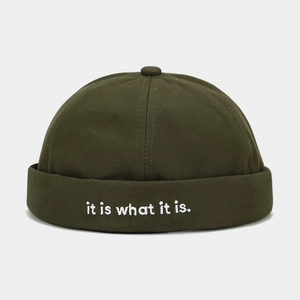 Close-up of dark green docker hat with it is what it is white letter embroidery