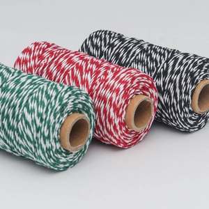 Close-up of red, green, and black bicolored cotton baker twine on paper spools