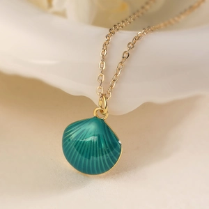 Detailed close-up of 18K gold plated shell pendant with green enamel and fine chain