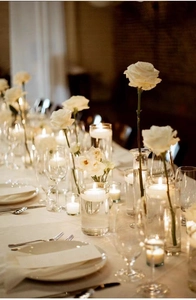 Detailopname van drijvende kaarsen en witte rozen op een elegante, romantische tafel