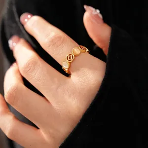 Bague vintage dorée avec motifs de pièces et pierres œil de chat ovales au doigt