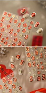 Detail of red and gold Chinese character nail stickers with lucky motifs on white glitter nails