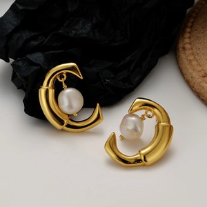 Detail shot of the golden crescent moon frame with lustrous cream baroque pearl