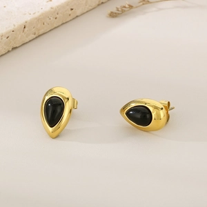 Détails macro de boucles d'oreilles goutte en plaqué or 18K et pierre oeil de chat