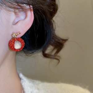 Detailed macro view of a cute sweet red resin apple earring with sparkling zircon accents