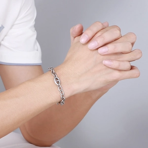 Detailed view of a silver Cuban link chain bracelet with a classic anchor H-link design