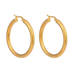 Macro view of polished gold hoop earrings featuring a glossy minimalist stainless steel finish
